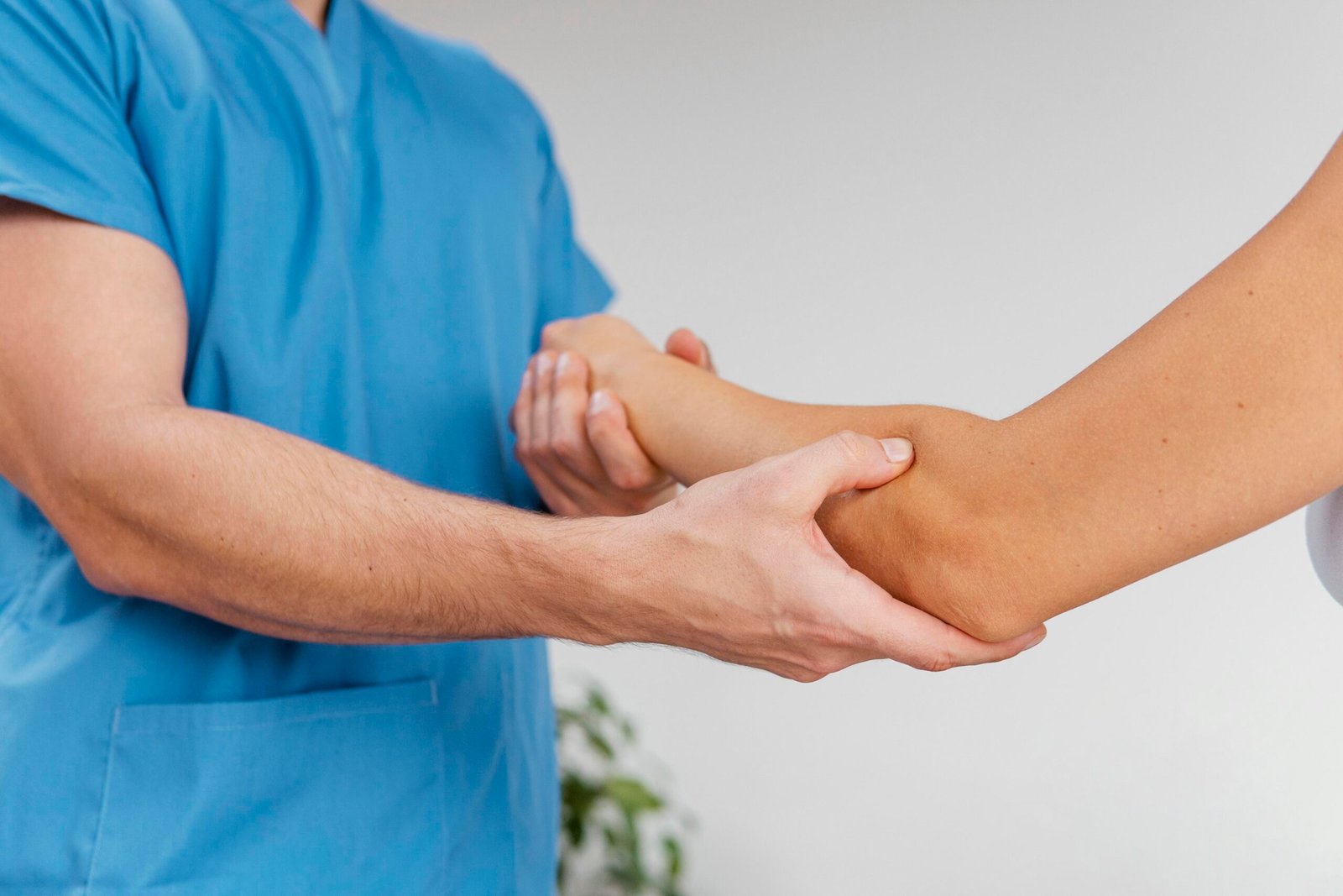 An orthopedist carefully examines a patient's elbow joint for signs of injury or pain.